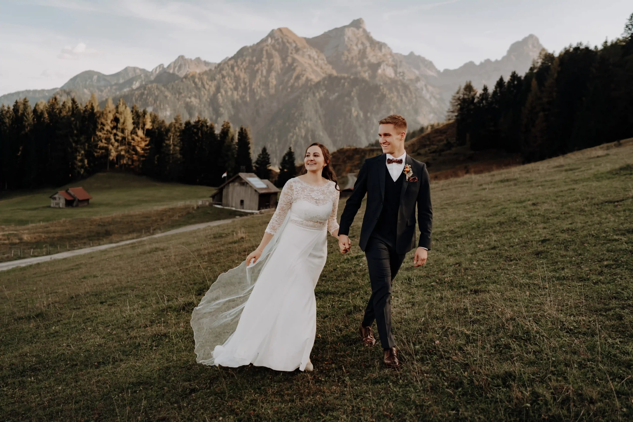 Brautpaar läuft auf einer Wiese mit tollem Bergblick bei Bludenz in Österreich, Freie Trauung auf der Rufana Alp in Österreich