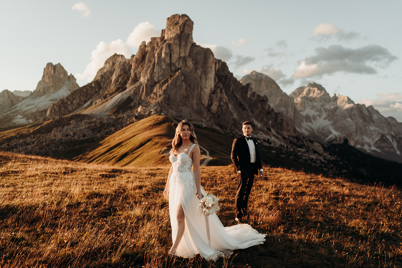 Couple standing in front of Passo Giau in the Dolomites and posing for photo